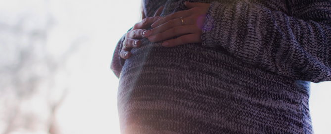 Grávida com mãos na barriga