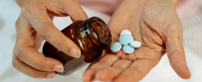 mãos segurando medicamento em comprimidos custeado pelo plano de saúde