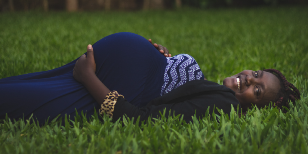 mulher grávida deitada na grama