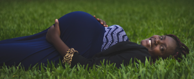 mulher grávida deitada na grama