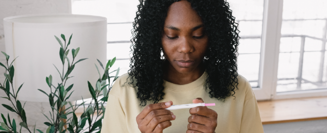mulher olhando para teste de gravidez