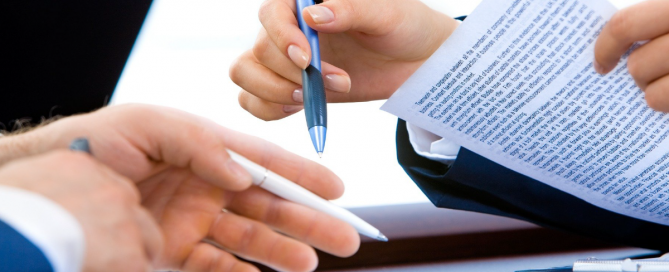 A imagem mostra mãos de duas pessoas com caneta e papel na mão