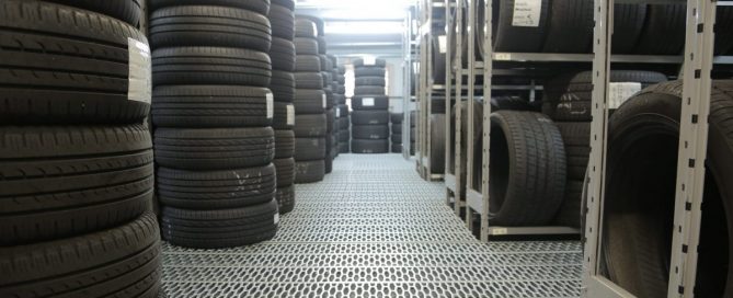 Foto de um estoque de loja com vários pneus empilhados.